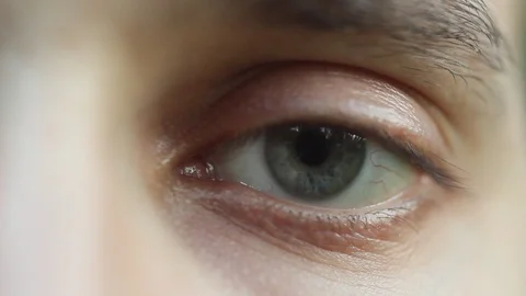 Blinking male eye close-up looking around. red artery on the eyeball macro Stock Footage 108377105