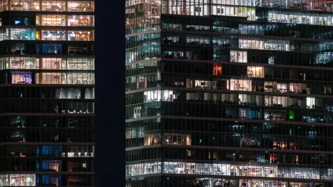 Blinking office window lights in business center skyscraper people work at night Stock Footage 176891286