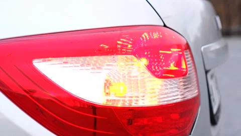 Blinking on a rear light of a silver modern car in a suburban area - side view Vídeos de archivo 165874052