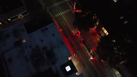 Blinking red lights of fire truck on street in american town at night. Aerial Stock Footage 308694594