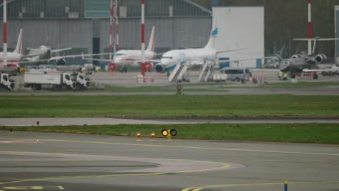 Blinking runway navigation lights at airport, terminal and parked aircraft 스톡 동영상 333647043