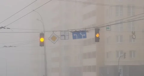Blinking yellow traffic lights at an intersection in the city, with a high-rise Video stock 226920144