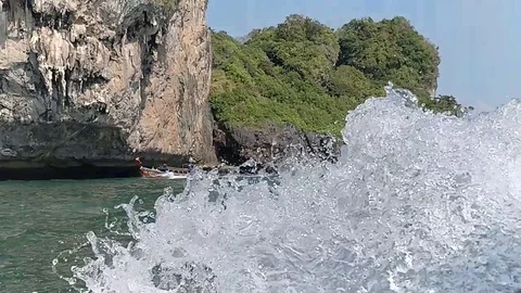 Blissful cliff side boat ride in slow motion Stock Footage
