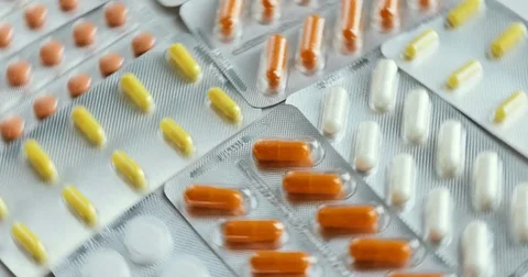 Blister with colorful capsules. Camera pans a top view of tablet quickly Stock Footage