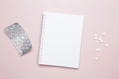 Blister of tablets and blank notebook. Concept of medicine, healthcare, and p Stock Photos