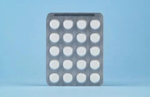 Blister of tablets on a light blue background. Stock Photos