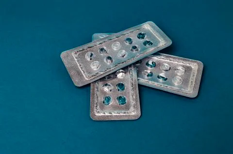 Blisters without tablets on a blue background closeup Stock Photos
