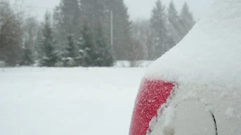 Blizzard against the background of the taillight of a car covered with snow Stock Footage 296811847