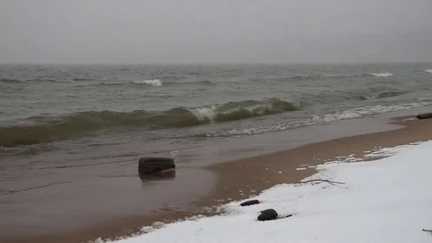 Blizzard and the running waves on the sandy snow coast of a reservoir Stock Footage 73512569