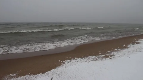 Blizzard and the running waves on the sandy snow coast of a reservoir Stock Footage 73512654