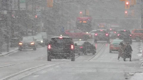Blizzard of snow with high wind and people waling  plus traffic in Toronto Stock Footage 171791867
