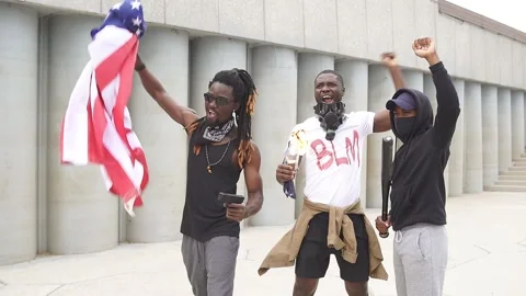 BLM march protest. Group of protesting young people with American flag on street Stock Footage 138530932
