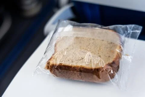 Bloated package of a piece of cake in cabin due to pressure in airplane flying Stock Photos