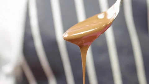 Blobs of hot chocolate fall from a spoon in slow motion Stock Footage 166863329