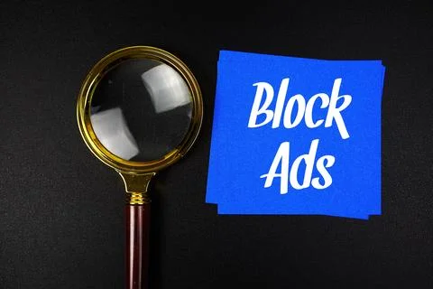 Block Ads text on sticky note with magnifying glass on black background Stock Photos