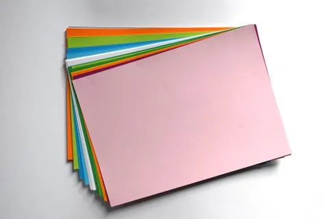 Block of colored A4 sheets on pink color illuminated by the sun  Stock-Fotos