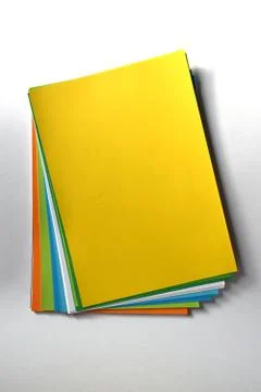Block of colored A4 sheets on a yellow color illuminated by the sun 스톡 사진