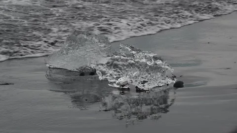 Block of ice on black and volcanic sand Stock Footage 318675255