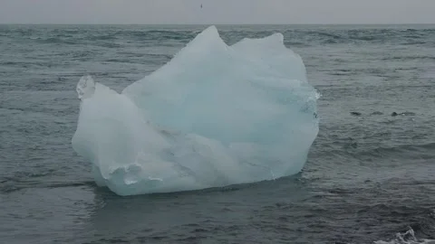 Block of ice on black and volcanic sand Stock Footage 318675326