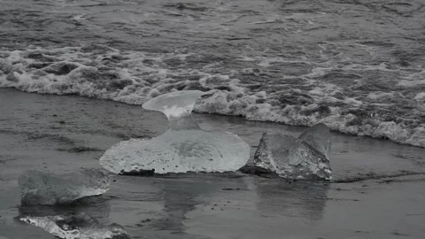 Block of ice on black and volcanic sand Stock Footage 318675328