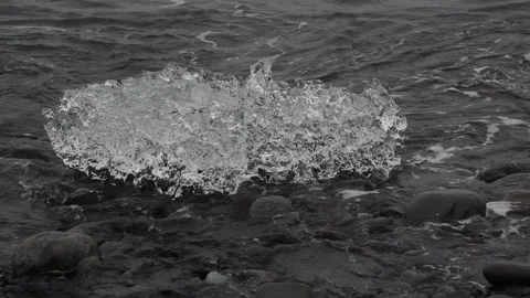 Block of ice on black and volcanic sand Stock Footage 318675332