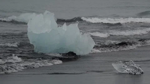 Block of ice on black and volcanic sand Stock Footage 318675615