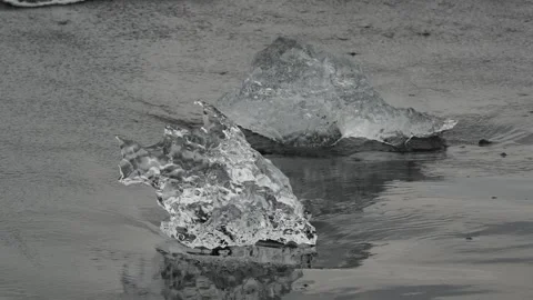 Block of ice on black and volcanic sand Stock Footage 318675648