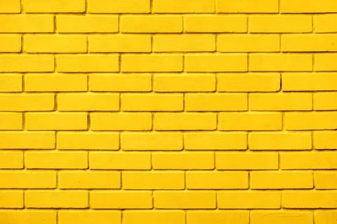 Block texture yellow painted wall brick background warm color. Painted bricks Foto stock
