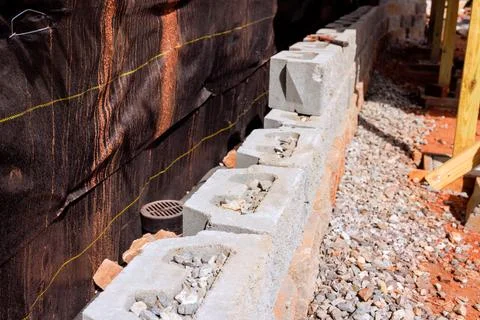 Block wall construction process on building site with exposed gravel suppor.. 스톡 사진