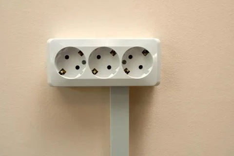 A block of white outlets consisting of three standard outlets with grounding Stock Photos