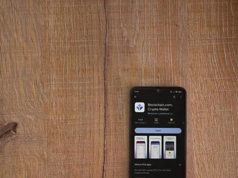 Blockchain.com app play store page on smartphone on wooden background Stock Photos