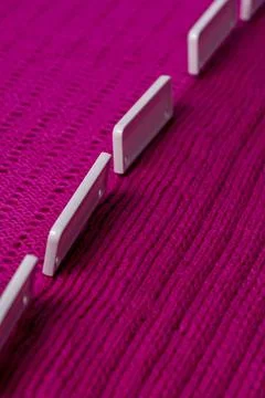 Blocking pins holding raspberry knitted project as it air dries Stock Photos