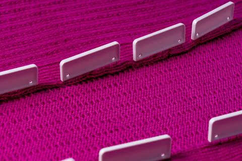 Blocking pins holding raspberry knitted project as it air dries Stock Photos
