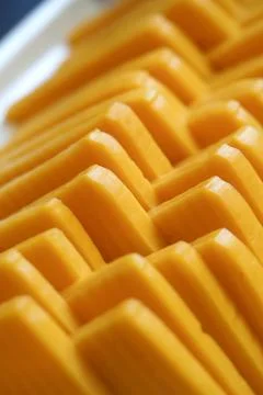 Blocks of cheese arranged in a neat pattern on a tray Stock Photos