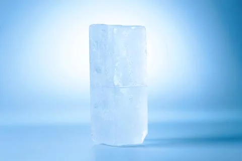 Blocks of clear ice on light blue background 스톡 사진