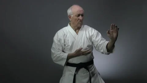 Blocks hands old man athlete performs on a gray background Stock Footage 139179042