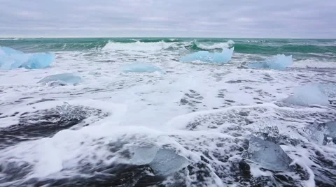 Blocks of ice washed by the waves on Jokursarlon beach. White nights in Icela Stock Footage 67095953