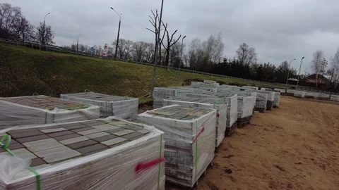 Blocks of paving stones stacked in a construction area near a roadside in a clou Stock Footage 337124321