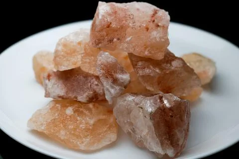 Blocks of pink himalayan salt on white plate cut-out. Stock Photos