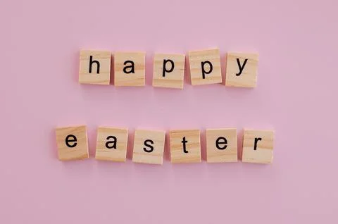 Blocks with the words Happy Easter on a pink background Stock Photos