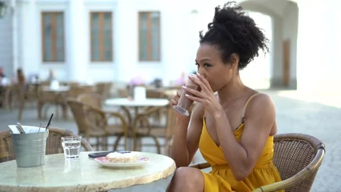 Blogger eats and drinks hot cocoa breakfast lunch in the city on the street. Stock Footage 154451508