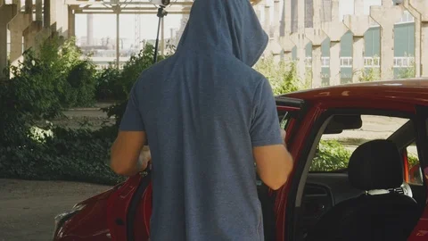 Blogger is filming on an action camera at the red car on the background of the Stock Footage 111865548