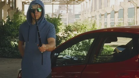 Blogger is filming on an action camera at the red car on the background of the Stock Footage 111865560