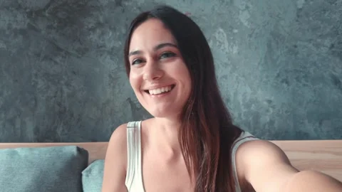 Blogger greets subscribers from sofa camera capturing moment As blogger she Stock Footage 259784107