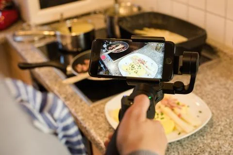 Blogger making smartphone video while preparing an asparagus dish Stock Photos