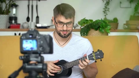 Blogger records video on camera, playing guitar. Video tutorial, music training. 動画素材 158367762