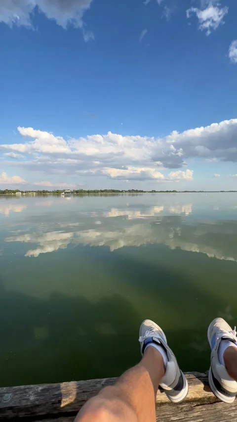 A blogger takes a panoramic view of the river from a wooden pier, with yachts Stock Footage 277631035