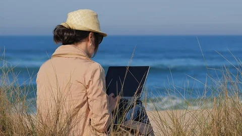 Blogger working in her notebook on beach Stock Footage 121378838