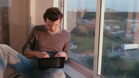 Blogger writes the article. Typing on a laptop sitting on the balcony at sunset. Stock Footage 102449552