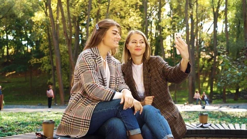 Bloggers using smartphone for live streaming in park Stock Footage 117668819